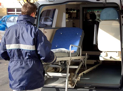 Travailleur d'urgence poussant un brancard dans l'arrière d'une ambulance à Paris 17eme arrondissement en Ile-de-France 75